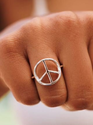 Pura Vida Peace Ring   Add joy and good vibes to any outfit with our Peace Sign Ring. This simple silver piece features a delicate band, with a cutout peace sign design that spreads love (and ‘70s style). on hand . 